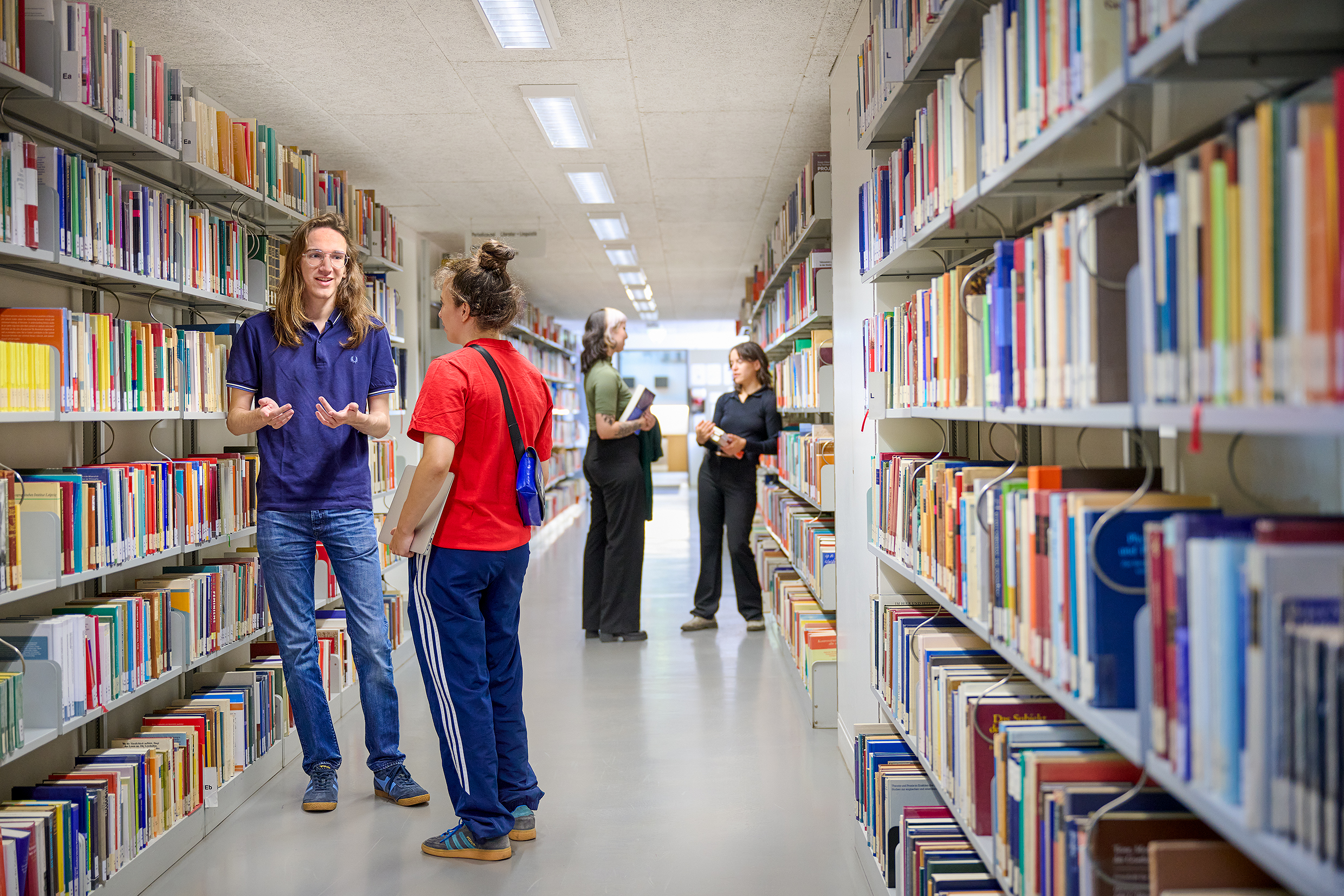 Das Bild zeigt eine Gruppe von Studierenden auf der Treppe vor dem Deutschen Seminar, sie sind ins Gespräch vertieft.