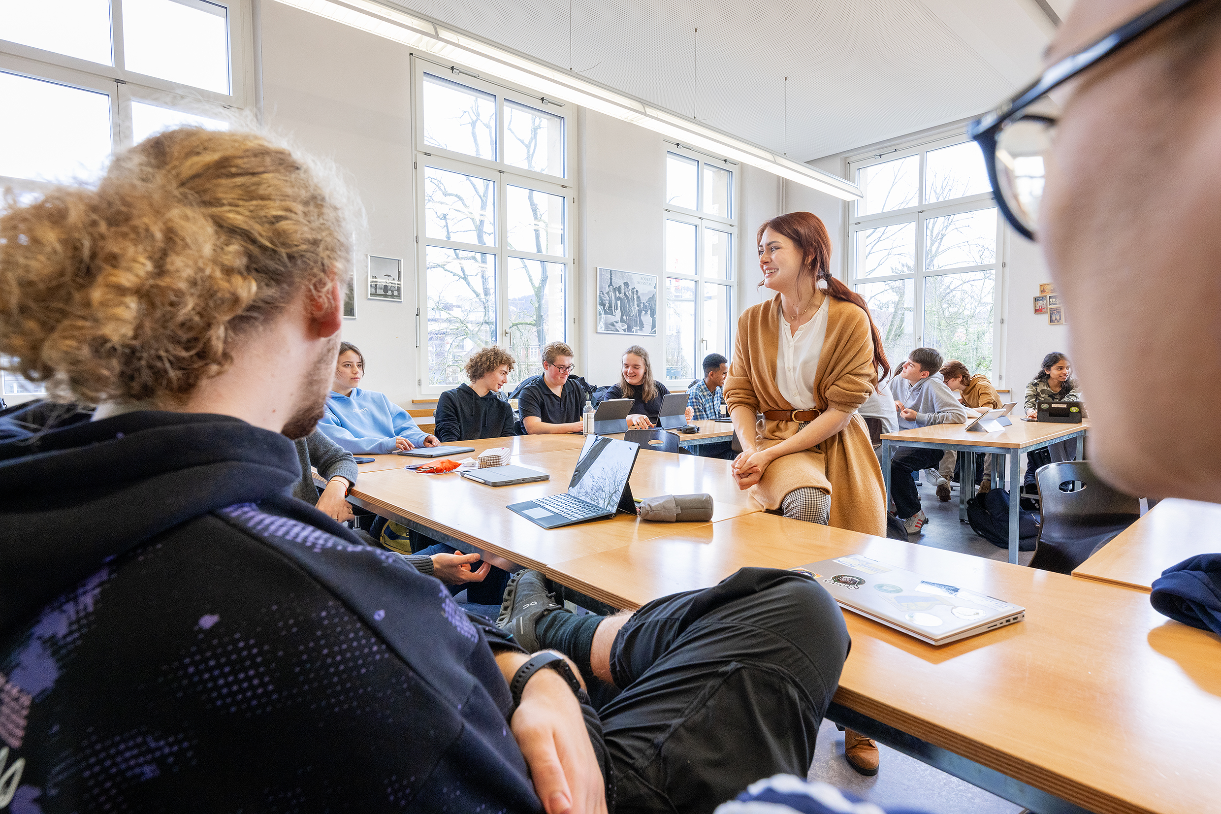 Das Bild zeigt drei runde Tische im Lernraum am Deutschen Seminar, an denen Studierende arbeiten.